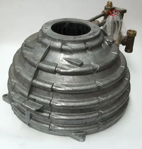 Stück aus Metall mit gewölbter, gestufter Oberfläche und Anschlussventilen, möglicherweise Teil eines Wärmetauschers von Daikin.